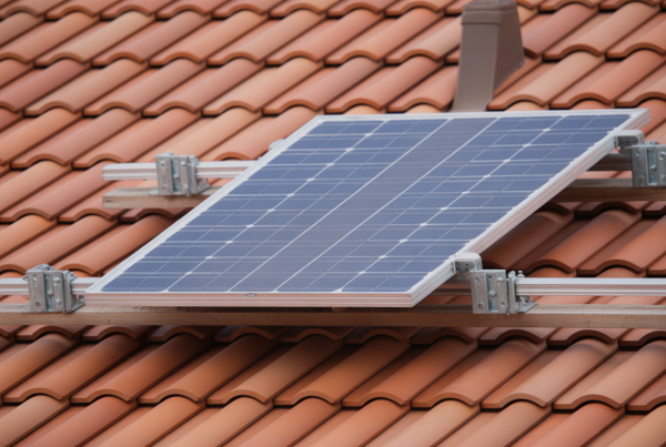 Panneau solaire fixé sur un toit en tuiles terre cuite avec supports métalliques visibles